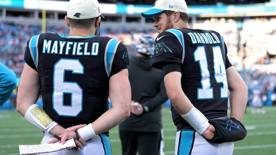 Carolina Panthers quarterbacks Baker Mayfield (left) and Sam Darnold on the team’s sideline in November 2022.