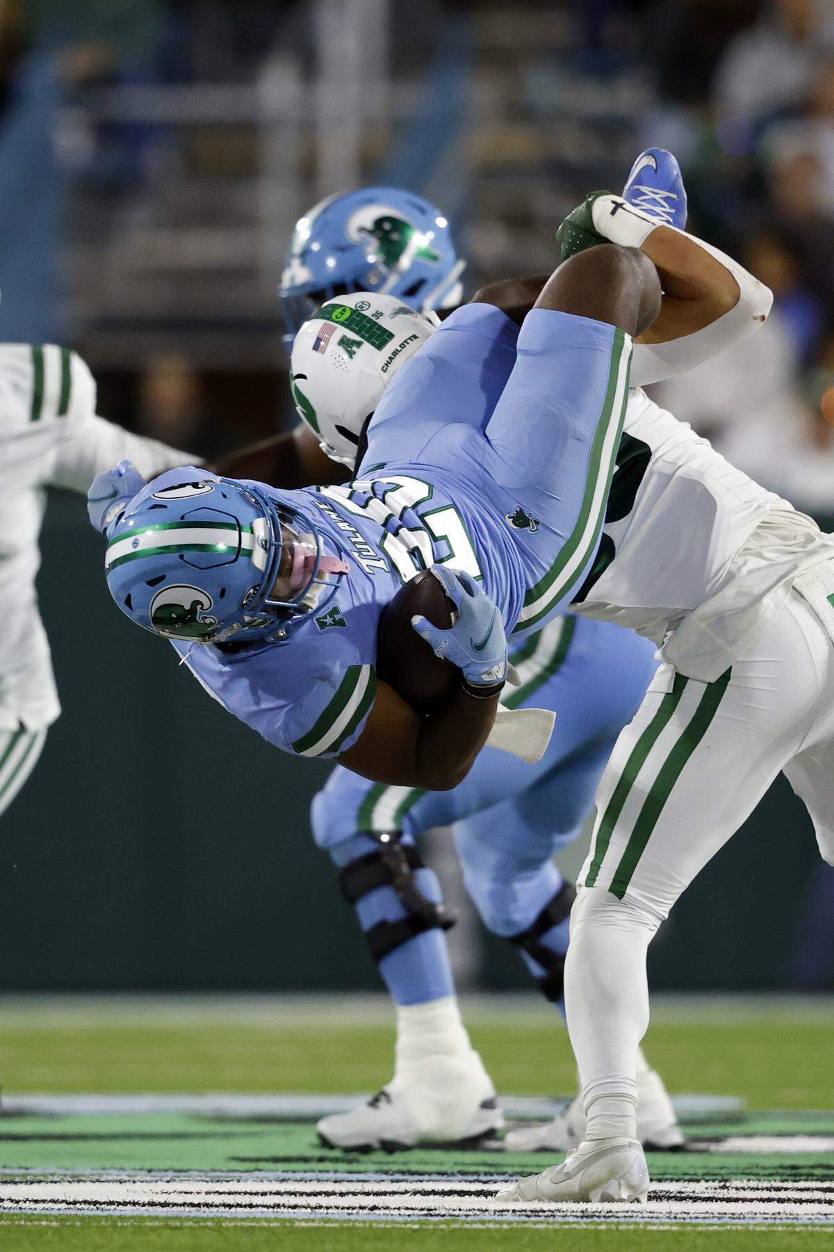 Tulane running back Arnold Barnes III (20) is defended by linebacker Shay Taylor (35) of the Charlotte 49ers during the first half at Yulman Stadium on Nov. 29, 2025 in New Orleans, Louisiana.