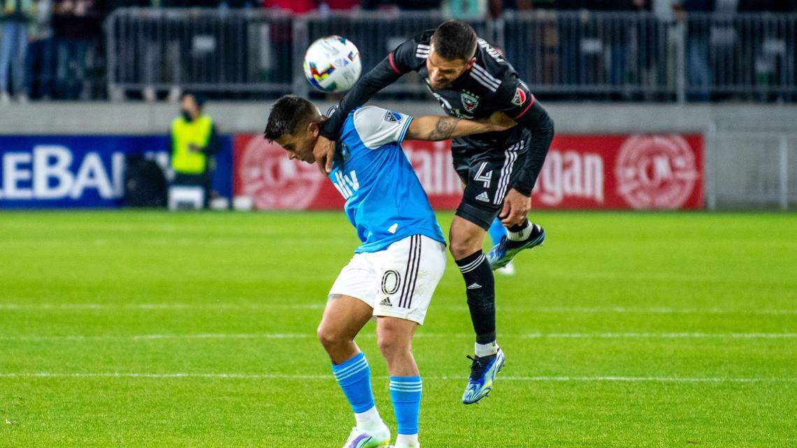 Charlotte FC’s Christian “Titi” Ortiz, left, and Brendan Hines-Ike battle for a header during Charlotte FC’s season-opening match against DC United on Feb. 26 at Audi Field in Washington, D.C. Ortiz was waived by the club Tuesday.