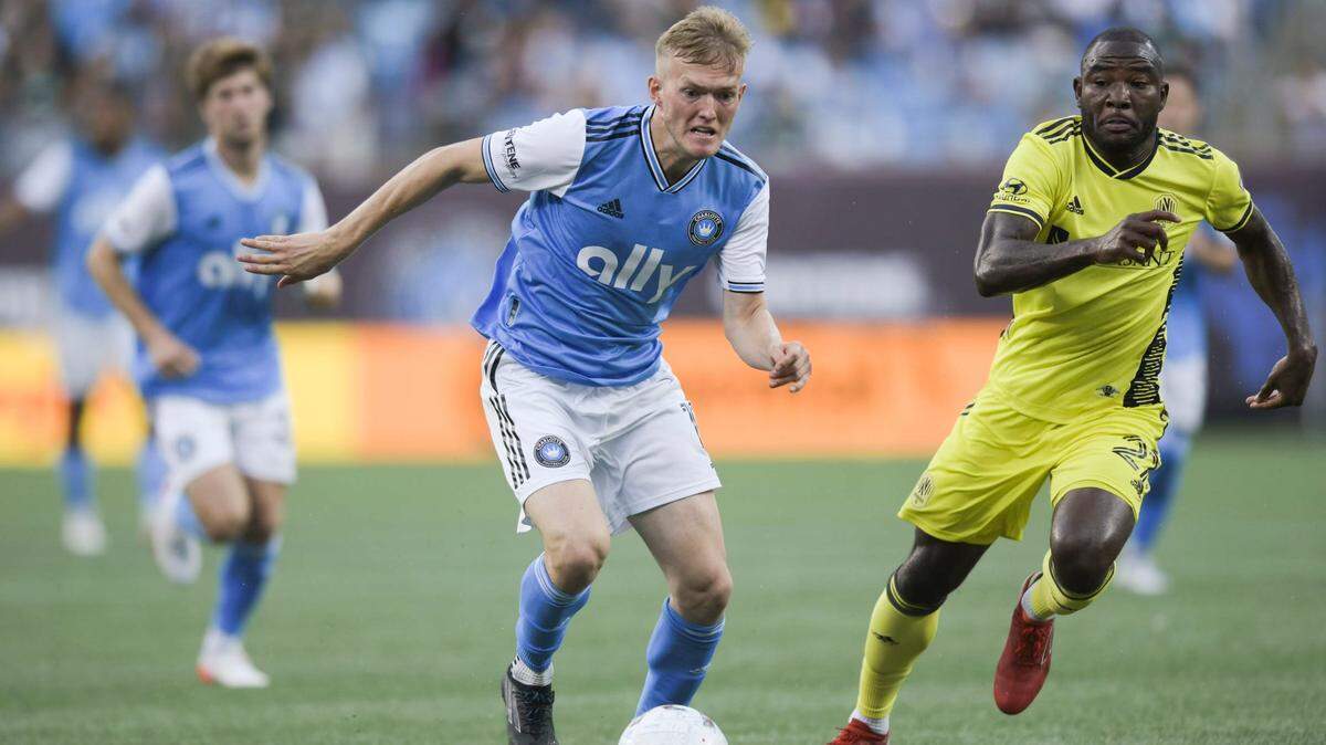 Charlotte FC forward Karol Swiderski (11) jockeys for control of the ball over Nashville SC midfielder Brian Anunga (27) during the first half of a match at Bank of America Stadium on Saturday.