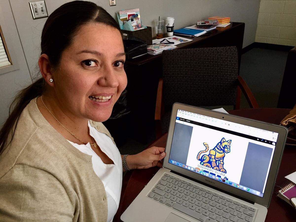 Principal Alejandra Garcia shows off the mascot for the new Governors’ Village STEM Academy, a “robotic cougar, like a Transformer.” The school was created by merging Nathaniel Alexander Elementary and Morehead STEM Academy.