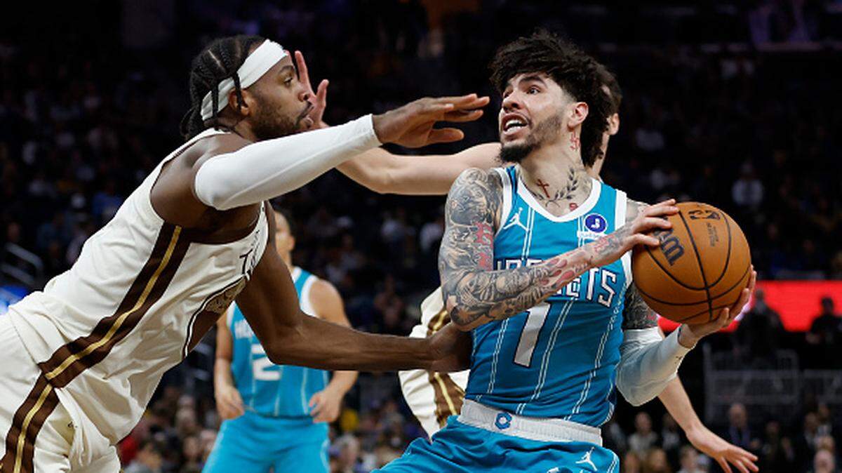 LaMelo Ball of the Charlotte Hornets looks to shoot the ball against Buddy Hield of the Golden State Warriors in the third quarter at Chase Center.