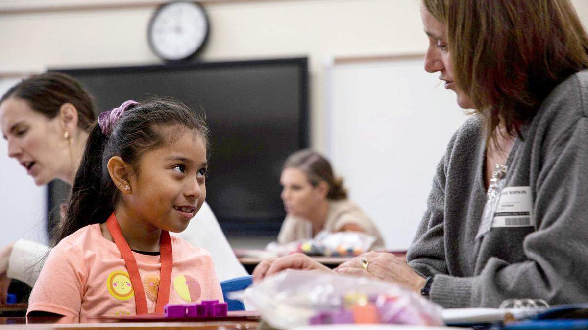 Suzy Nurkin helps a child with subtraction using blocks in a Heart Math tutoring session at Lansdowne Elementary on Wednesday, Nov. 9, in Charlotte, NC.