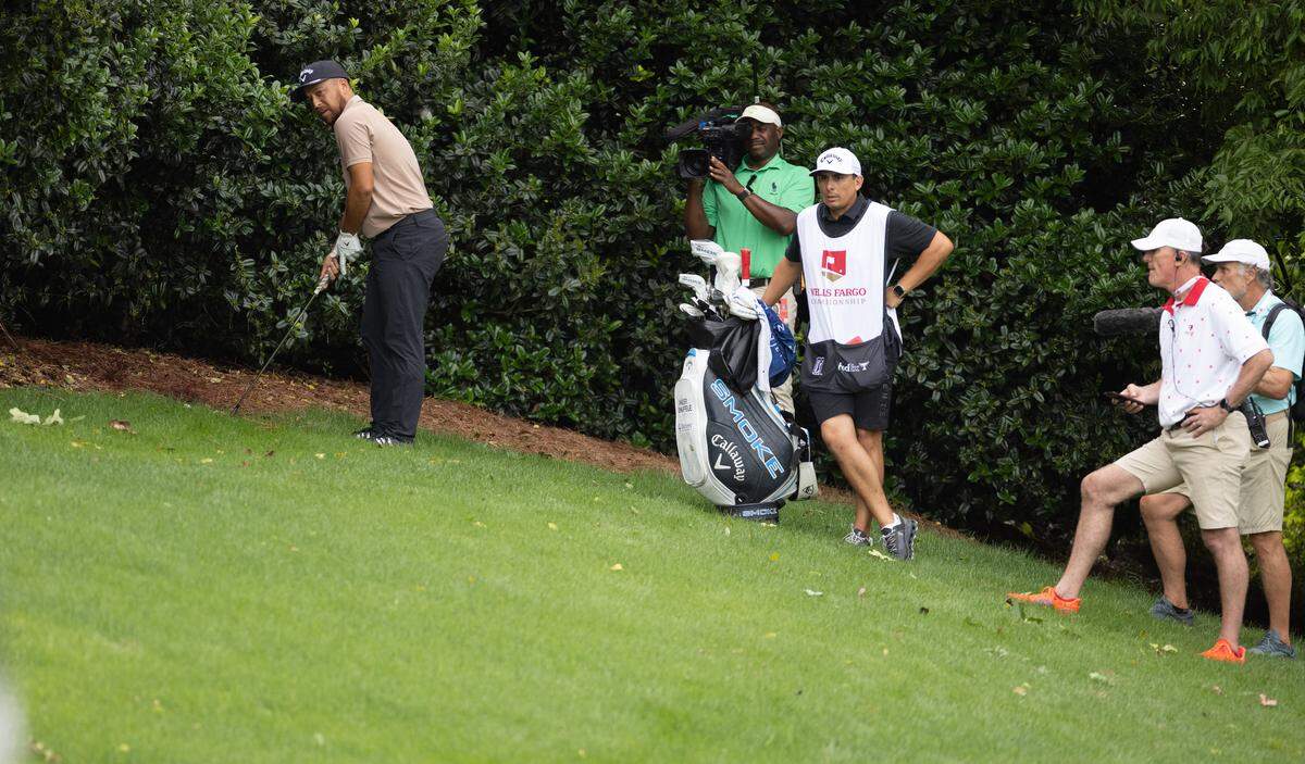 Xander Schauffele hits on the 8th hole after losing his ball in the woods during round one of the Wells Fargo Championship at Quail Hollow Club in Charlotte, N.C., on Thursday, May 9, 2024.