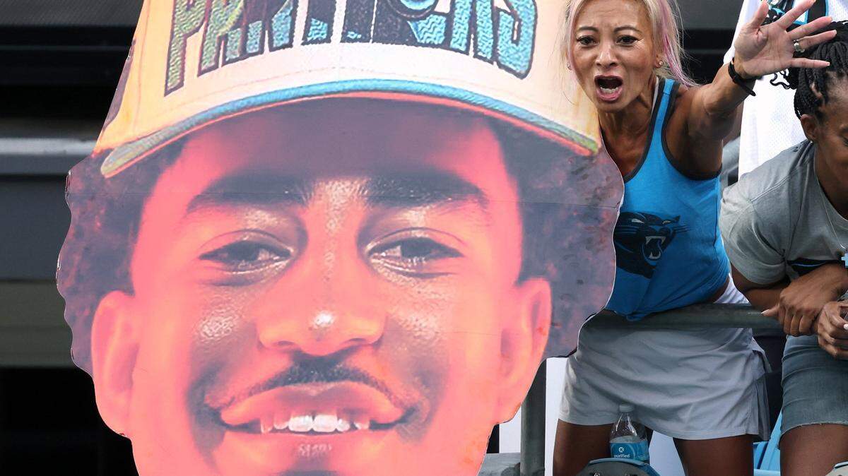 A Carolina Panthers holds a large head photo of rookie quarterback Bryce Young during the team’s Fan Fest practice at Bank of America Stadium on Wednesday, August 2, 2023.