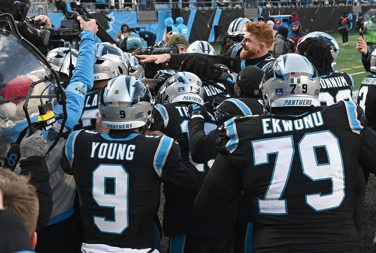 Members of the Carolina Panthers swarm running back Chuba Hubbard following his game winning touchdown run in overtime to defeat the Arizona Cardinals at Bank of America Stadium in Charlotte, NC on Sunday, December 22, 2024. The Panthers defeated the Cardinals in overtime 36-30