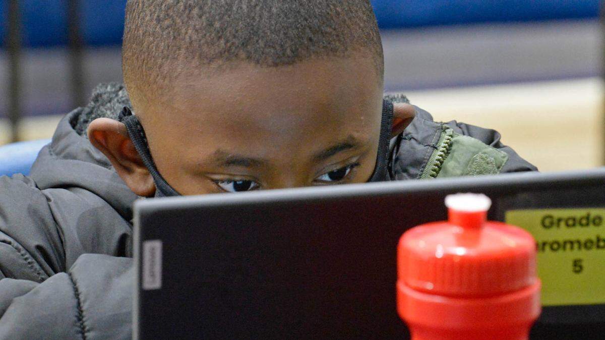 A student looks down on his laptop screen while working on his lesson at the YMCA of Greater Charlotte’s School Days+ remote learning program at the Stratford Richardson YMCA on Feb. 3, 2021.