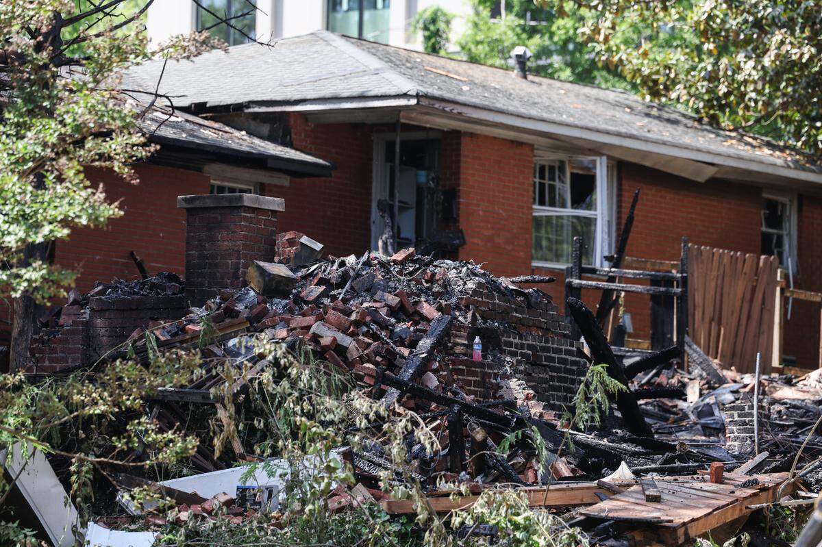 Charlotte Fire Department officials work at the site of a house fire near Freedom Park after an explosion was reported early morning in Charlotte, NC on Friday, May 2, 2025.