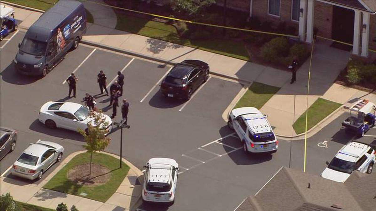 In this image from Observer news partner WSOC, Charlotte-Mecklenburg police officers investigate the area around an apartment complex after a person was found shot in the 600 block of Sawyers Mill Road on Tuesday, Aug. 23, 2020. Paramedics pronounced the person dead.