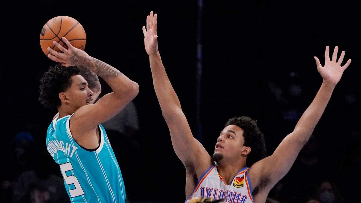 Charlotte Hornets guard James Bouknight (5) passes in front of Oklahoma City Thunder forward Jeremiah Robinson-Earl, right, in the second half Monday in Oklahoma City.