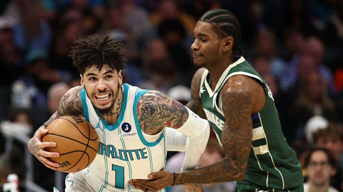 LaMelo Ball of the Charlotte Hornets drives to the basket against Kevin Porter Jr. of the Milwaukee Bucks during the first quarter of the game at Spectrum Center.