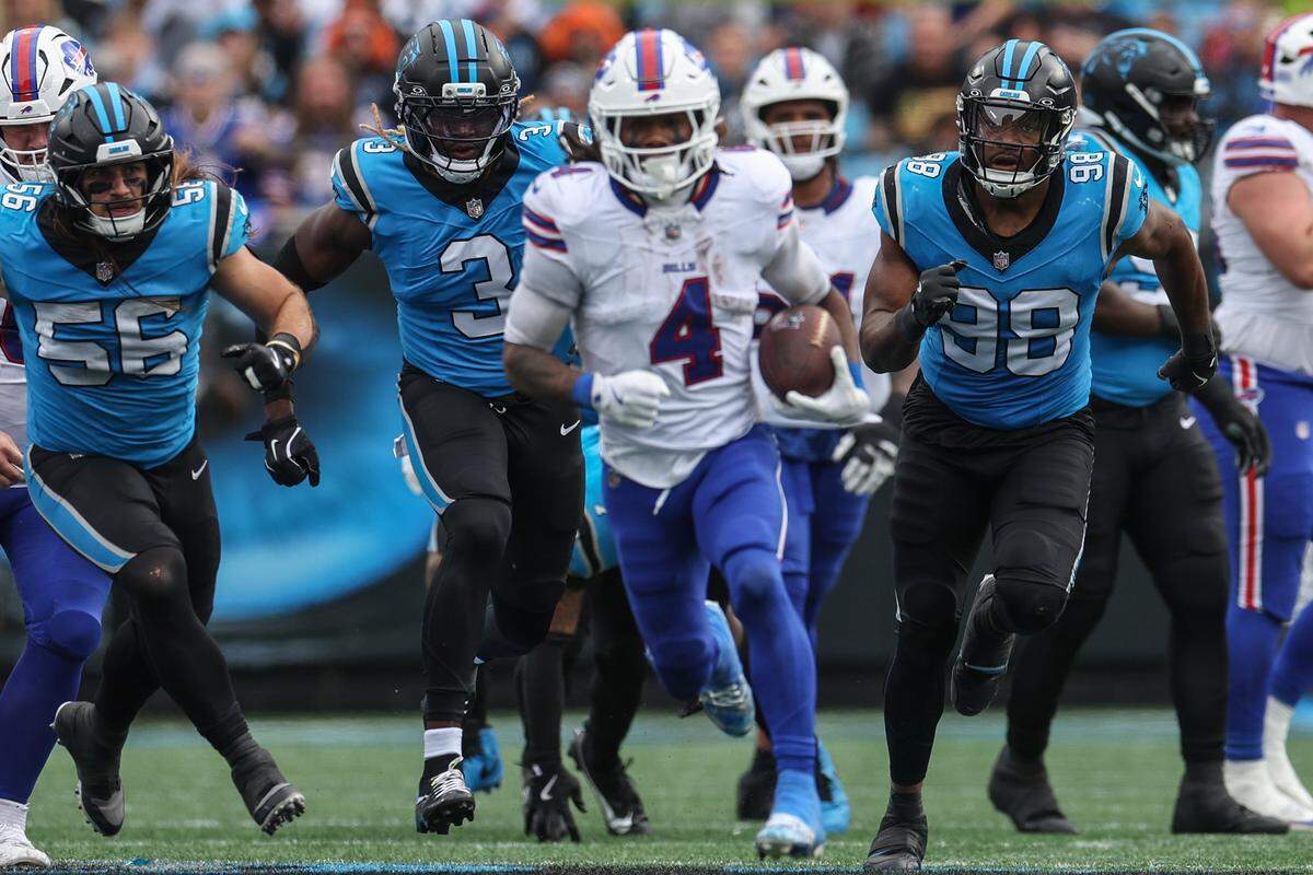 Panthers defensive players Christian Rozeboom, left, Princely Umanmielen, second from left, and D.J. Wonnum pursue Bills wide receiver James Cook as he runs toeard the end zone during the game at Bank of America Stadium in Charlotte, NC on Sunday, October 26, 2025.