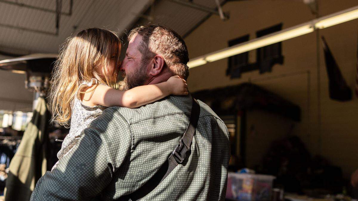 Adam Smith holds his daughter, Tove, 3, at Savage Operations Center inside of a Harley Davidson store in Swannanoa, N.C. on Tuesday, October 8, 2024.