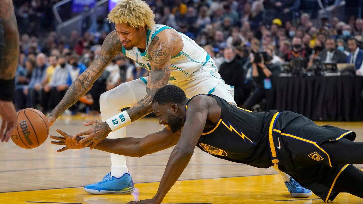 Golden State Warriors forward Draymond Green, bottom, knocks the ball forward from Charlotte Hornets guard Kelly Oubre Jr. during the second half of an NBA basketball game in San Francisco, Wednesday, Nov. 3, 2021. (AP Photo/Jeff Chiu)