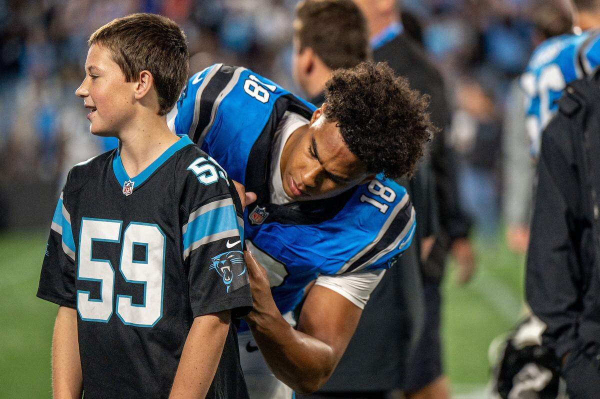 Carolina Panthers wide receiver Jalen Coker signs a jersey during the Carolina Panthers' FanFest during the summer at Bank of America Stadium.