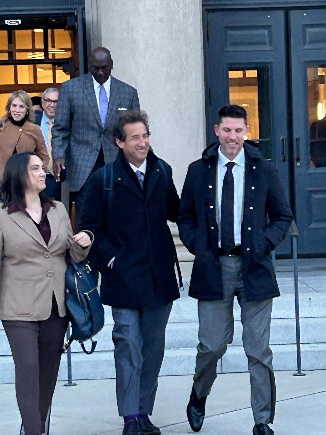Denny Hamlin (front right) and Michael Jordan (back) are the co-owners of 23XI Racing, one of the plaintiffs in a lawsuit accusing NASCAR of being an unlawful monopoly. They are shown leaving a Charlotte courtroom on Dec. 3, 2025.