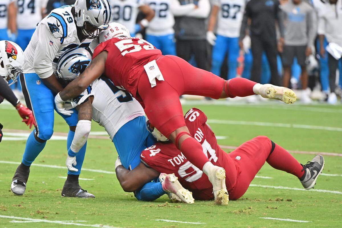 Carolina Panthers quarterback Bryce Young (9) is tackled by Arizona Cardinals defensive tackle Dalvin Tomlinson (94) and linebacker Jordan Burch (52) during the first quarter at State Farm Stadium in Glendale, Ariz., on Sunday, Sept. 14, 2025.