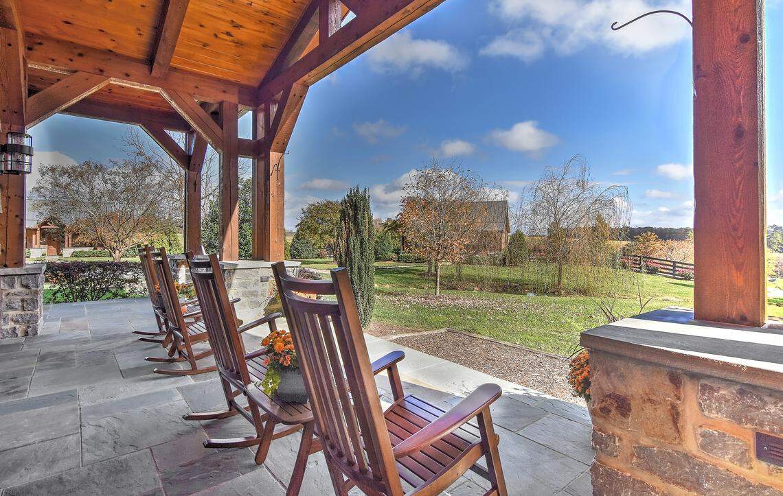 Sit on the porch and take in stunning views of the lush landscape and barn.