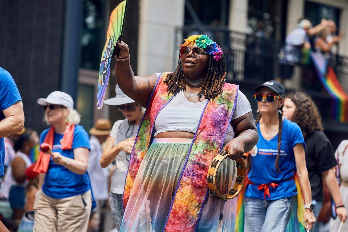The Unitarian Universalist Community of Charlotte makes their way through the parade route during the 25th Charlotte Pride Parade in uptown Charlotte on August 17, 2025.