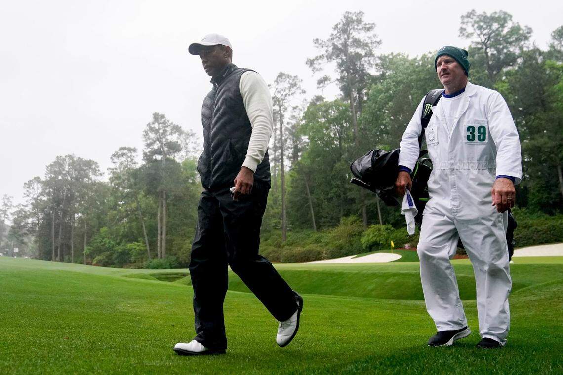 Tiger Woods walks to the 14th tee with caddie Joe LaCava during the second round of The Masters golf tournament in 2023.