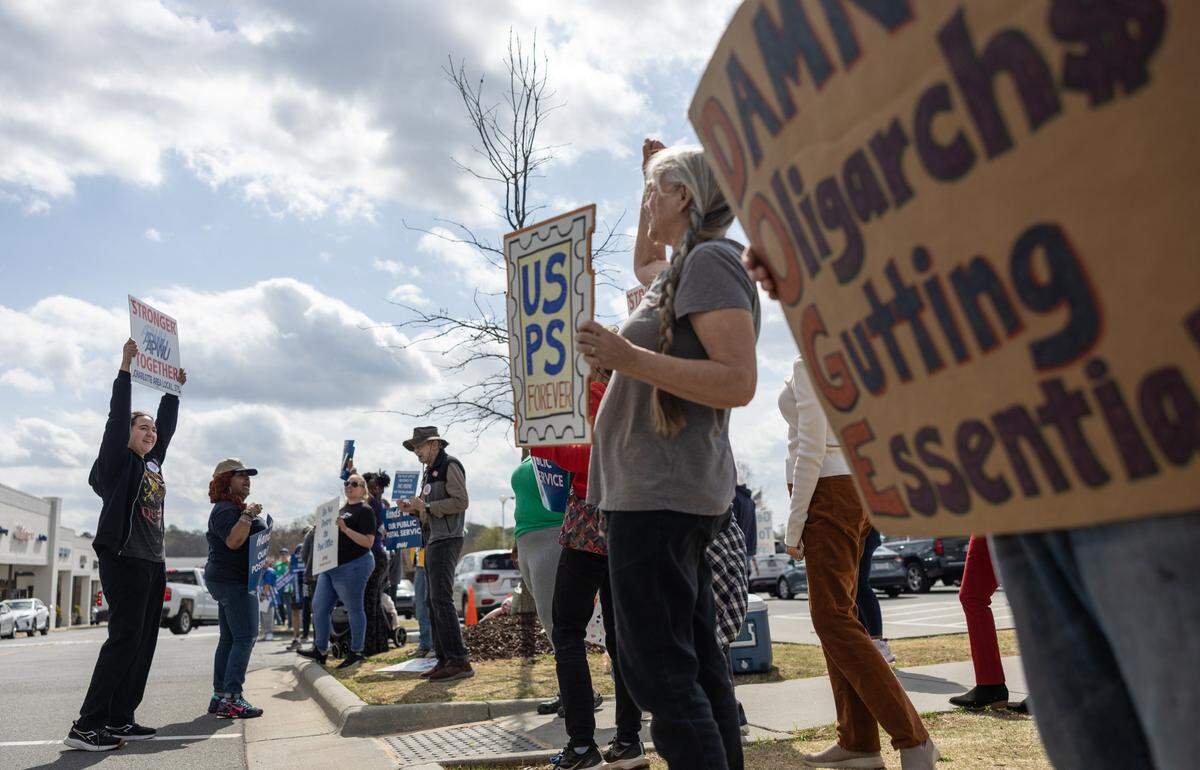 Protesters gather on the sidewalk during the U.S. Mail Not For Sale - Day of Action rally outside of the USPS Park Road office in Charlotte, N.C., on Thursday, March 20, 2025.