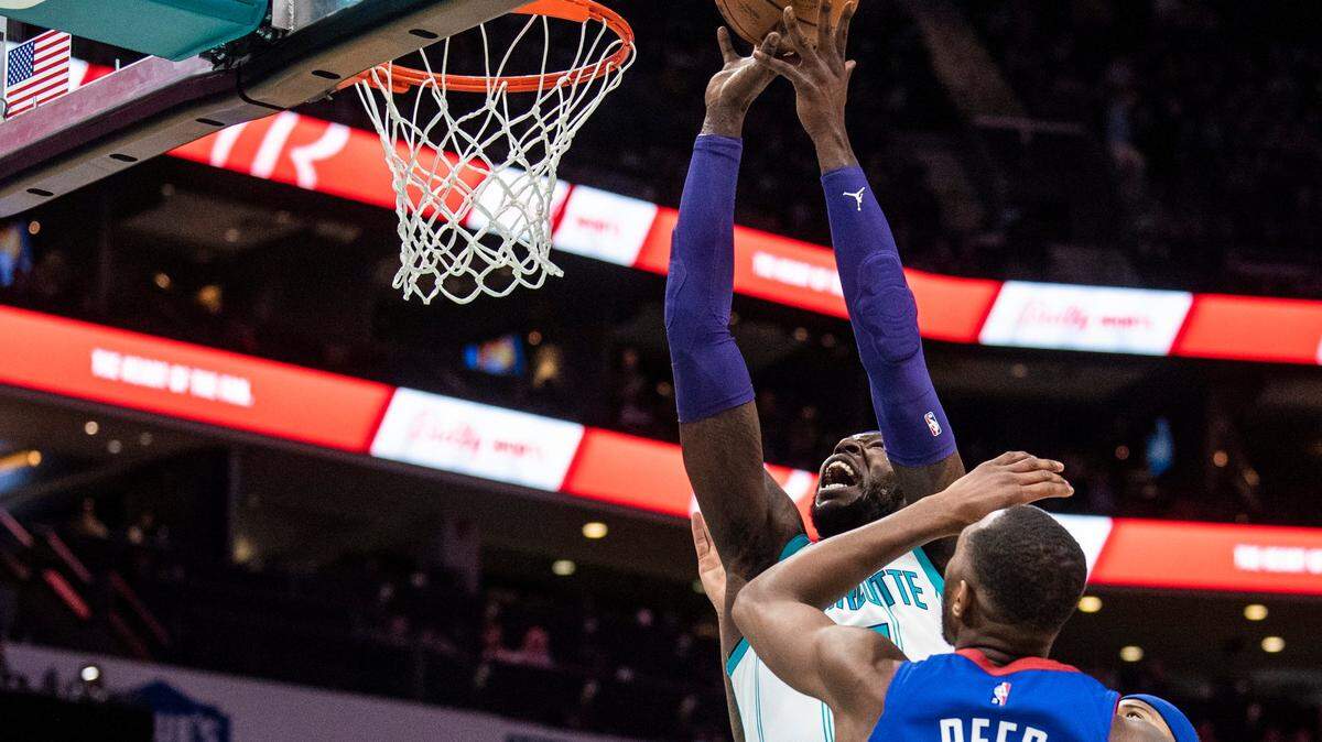 The Hornets Montreal Harrell, back center, takes the ball to the hoop over the Nuggets Davon Reed during the game at Spectrum Center on Monday, March 28, 2022 in Charlotte, NC.