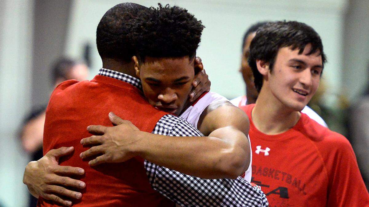 Northside Christian Academy’s Rayjon Tucker (24) hugs head coach Byron Dinkins following the team’s victory over Gaston Day School 58-53 on Friday, February 13, 2015 at Northside Christian Academy in Charlotte, NC. Northside defeated Gaston Day School to win the Metrolina Athletic Conference Basketball Tournament Championship.