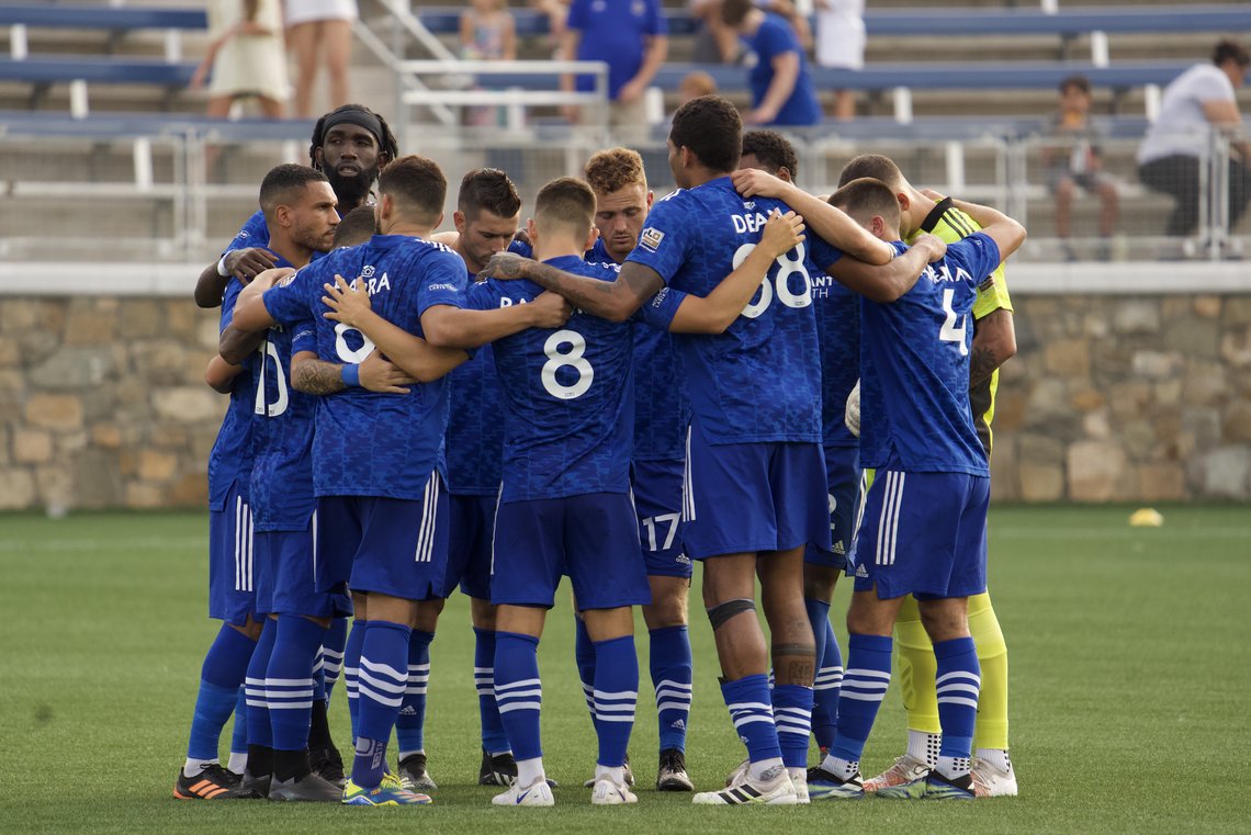 The Charlotte Independence soccer team huddles during a game.