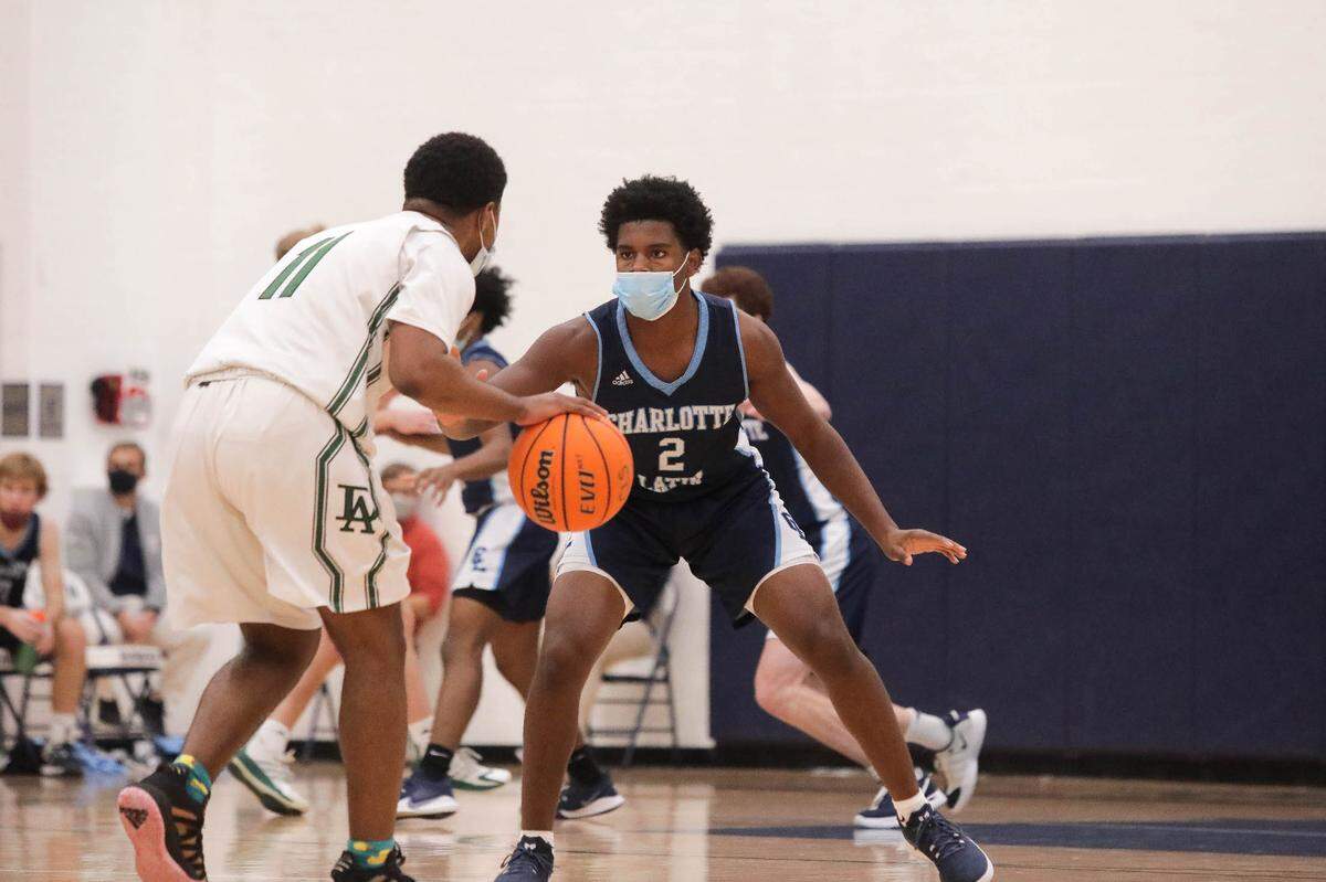 Charlotte Latin’s Daniel Haughton defends Durham Academy’s Cole Sinclair during Friday’s game