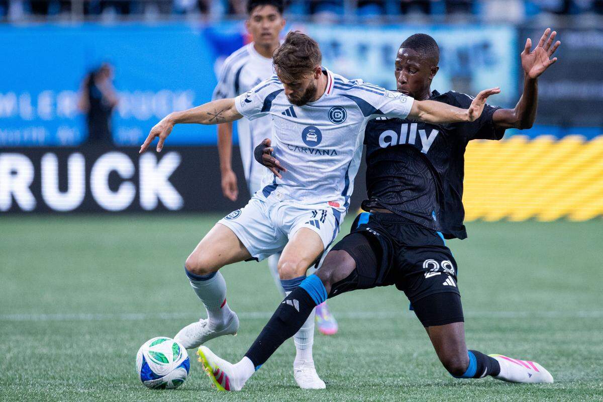 Charlotte FC midfielder Djibril Diani (28) knocks the ball away from Chicago Fire forward Philip Zinckernagel (11) during the first half at Bank of America Stadium.