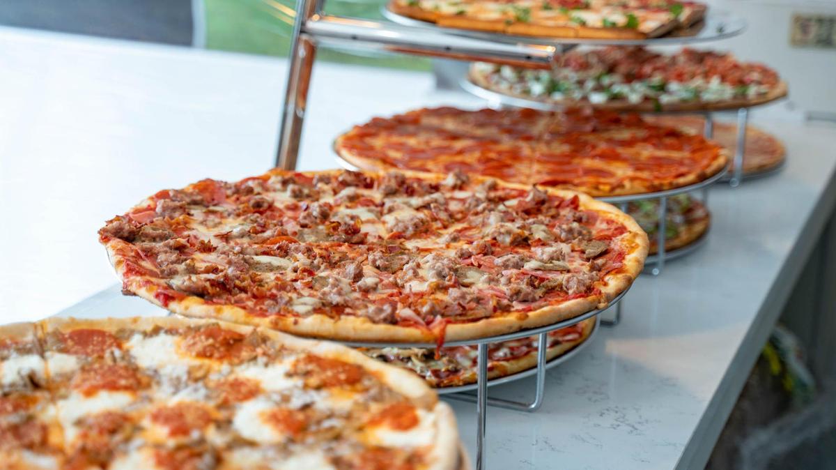 Pizzas are lined up on display at Sal’s Pizza Factory for daily lunch slices.