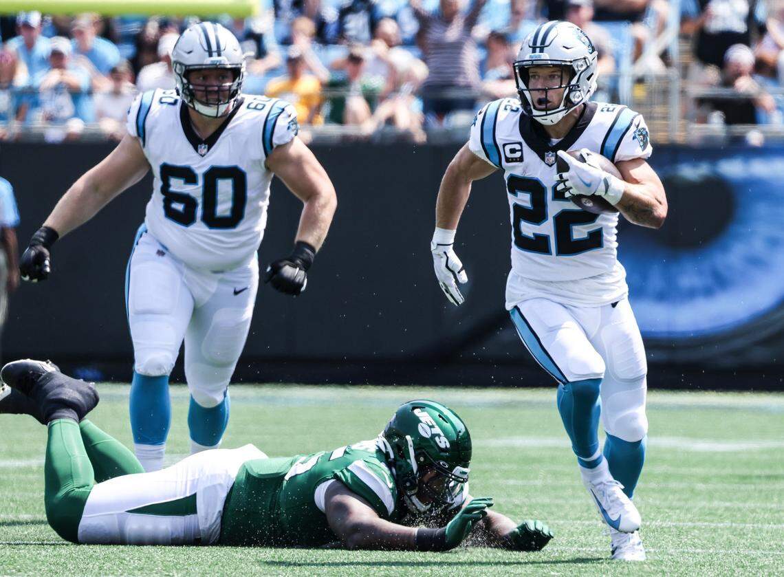Carolina Panthers Christian McCaffrey, right, runs the ball at the Bank of America Stadium in Charlotte, N.C., on Sunday, September 12, 2021.