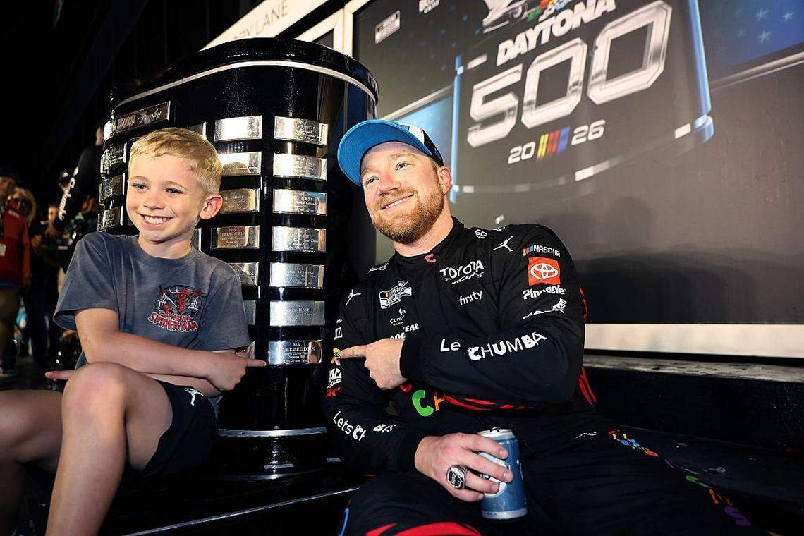 DAYTONA BEACH, FLORIDA - FEBRUARY 15: Tyler Reddick, driver of the #45 Chumba Casino Toyota, and son, Beau Reddick pose for photos with the Harley J. Earl Trophy in victory lane after winning the NASCAR Cup Series Daytona 500 at Daytona International Speedway on February 15, 2026 in Daytona Beach, Florida. (Photo by James Gilbert/Getty Images)