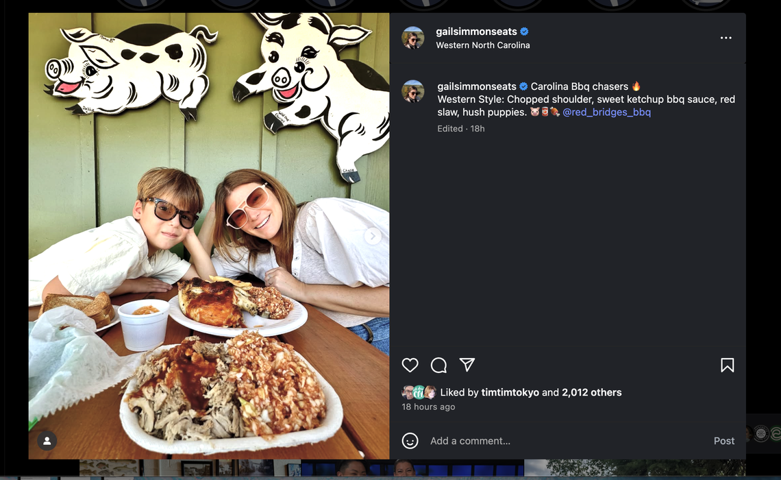 A screenshot of an Instagram post by Gail Simmons. The main image shows Gail and a young boy smiling at a wooden table in front of a large plate of chopped barbecue. On the green wall behind them are whimsical cutouts of a pig and a cow. The post’s caption identifies the meal as “Western Style” barbecue with “chopped shoulder, sweet ketchup bbq sauce, red slaw, hush puppies” from Red Bridges Barbecue Lodge.