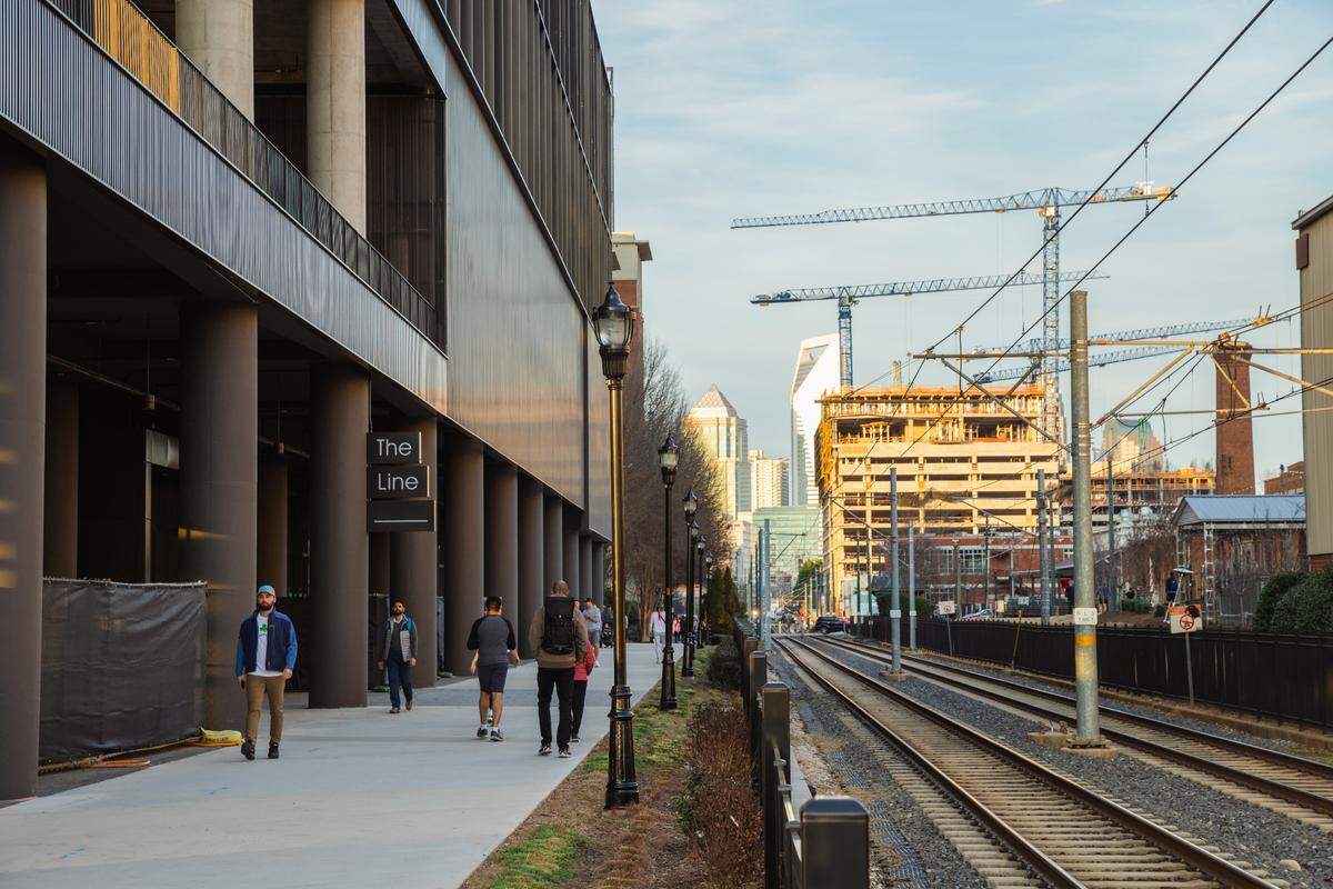 Cranes tower over buildings under construction near the Charlotte Rail Trail.