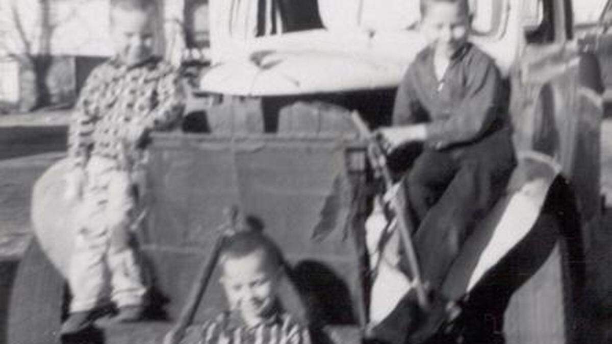l-r brothers Danny, Randy and Dale Earnhardt play on their father, Ralph’s racer when Dale was about 8 years old. Randy, front, is on a soap-box derby racer.