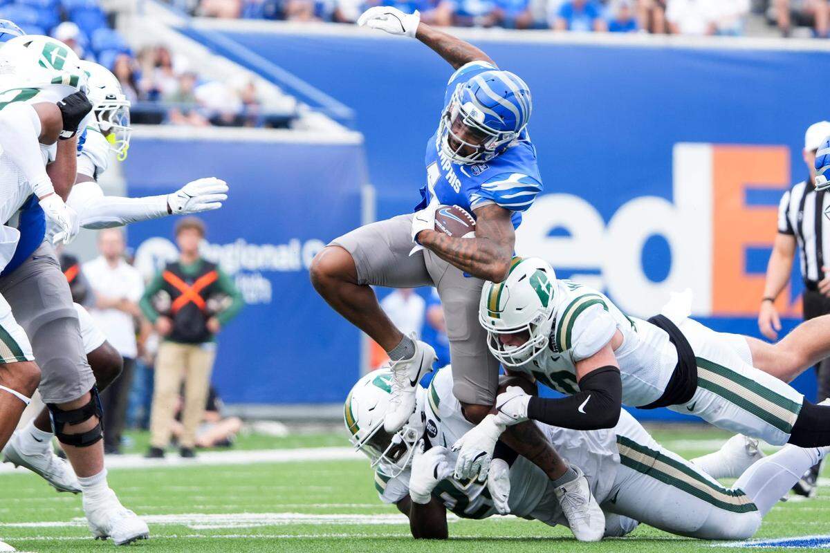 Memphis’ Jyaire Shorter (4) jumps through the air as he is tackled while running with the ball during the game between Charlotte and the University of Memphis at Simmons Bank Liberty Stadium on Saturday, October 26, 2024.