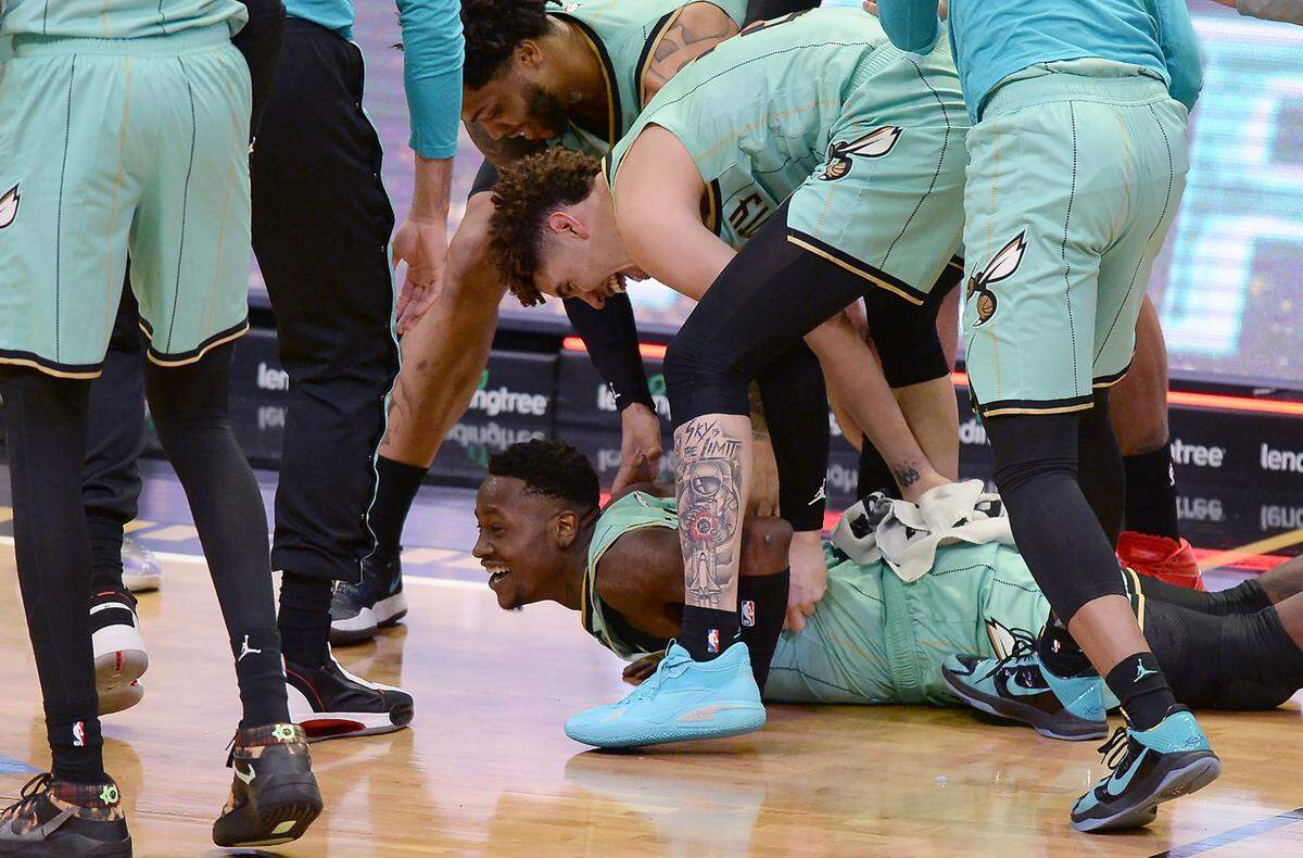 Charlotte Hornets guard Terry Rozier, center, smiles as he and his teammates celebrate his game-winning basket at the buzzer to beat the Golden State Warriors on Saturday, February 20, 2021 at Spectrum Center in Charlotte, NC. The Hornets defeated the Warriors 102-100 on Rozier’s buzzer-beater. Rozier scored the game’s final four points in the final 9.3 seconds.