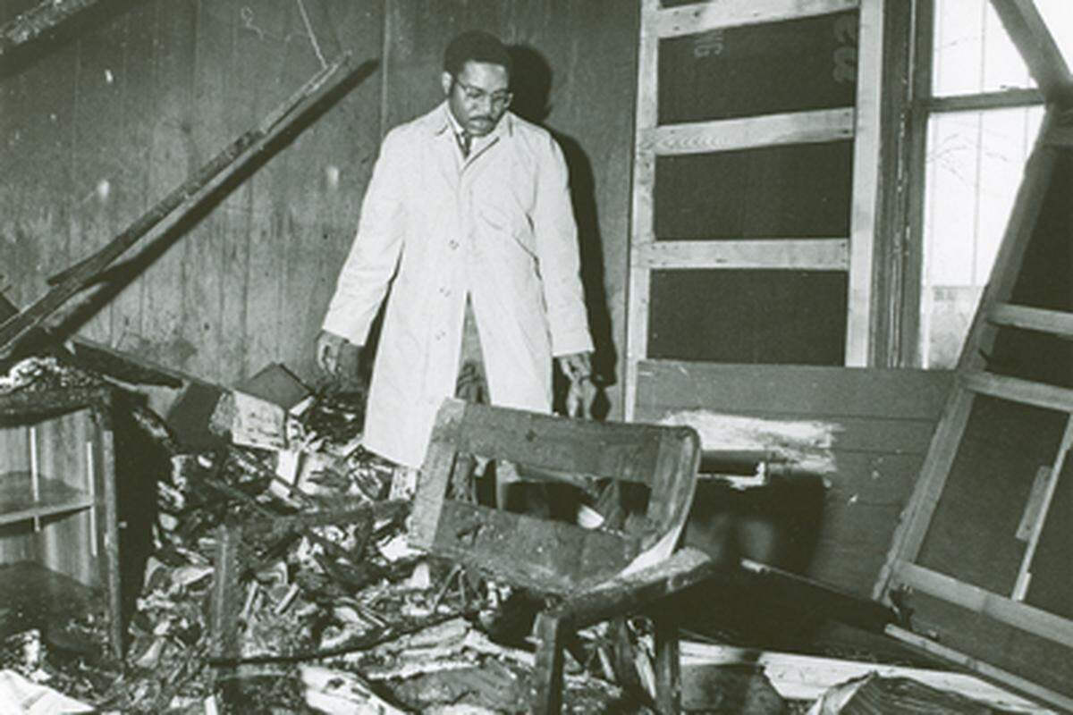Lawyer Julius Chambers  searches through his firebombed office in Charlotte, NC in February, 1971. His Charlotte home and car also were firebombed in 1965. 