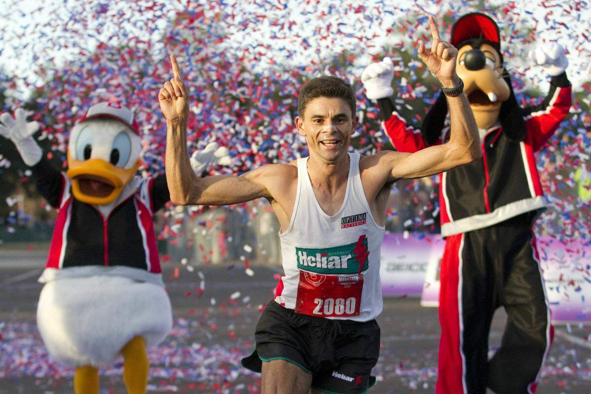 LAKE BUENA VISTA, FL - JANUARY 09: In this handout image provided by Disney, Fredison Costa, 33, from Brazil and now living in El Paso, Texas, celebrates January 9, 2011 as he crosses the finish line to win the Walt Disney World Marathon in Lake Buena Vista, Florida with an unofficial time of 2:21:14. More than 17,500 runners were registered for the annual 26.2-mile run through all four Disney theme parks. (Photo by Matt Stroshane/Disney via Getty Images)