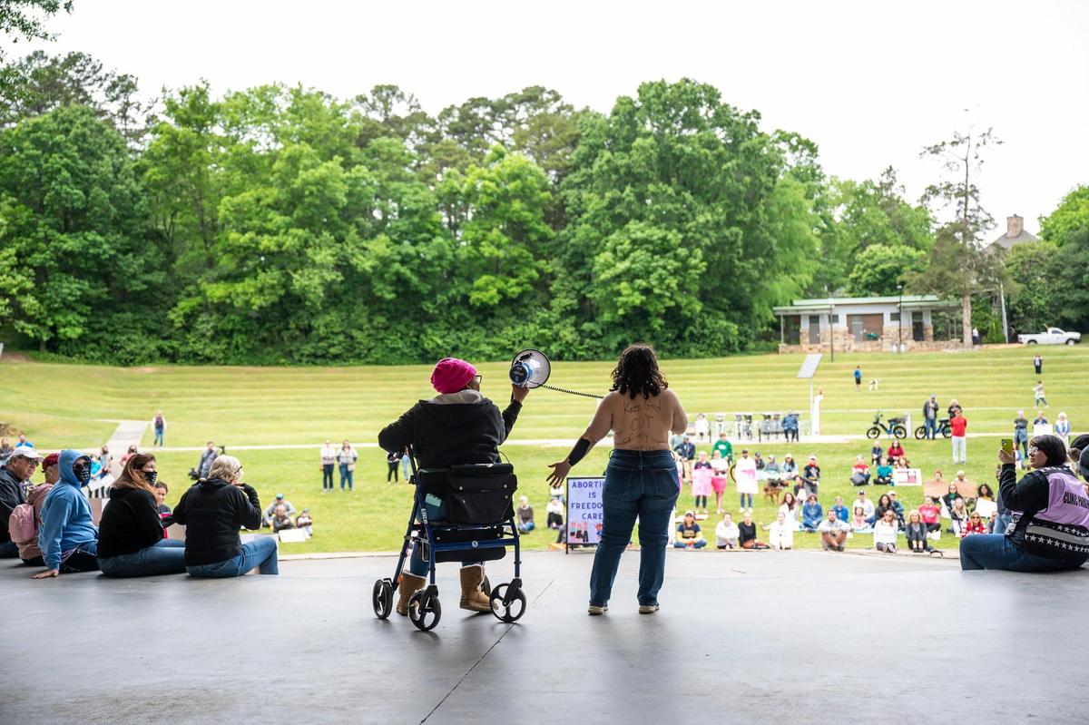 Tina Marshall, left, with Black Abortion Defense League, holds the bullhorn as Coral Kirkwood Enosh speaks at the Mother’s Day protest supporting abortion rights.