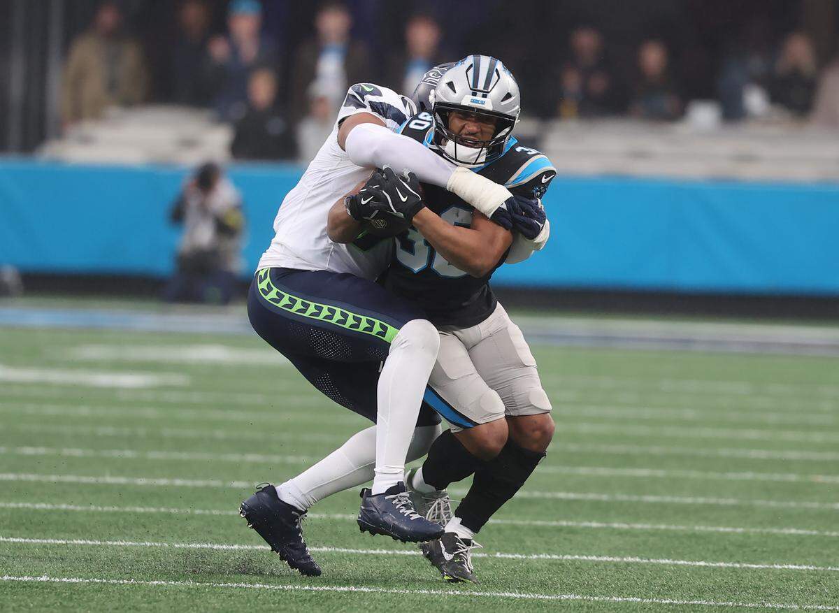 Seattle Seahawks’ Uchenna Nwosu tackles Carolina Panthers’ Chuba Hubbard during the game at Bank of America Stadium in Charlotte on Sunday, Dec. 28, 2025.