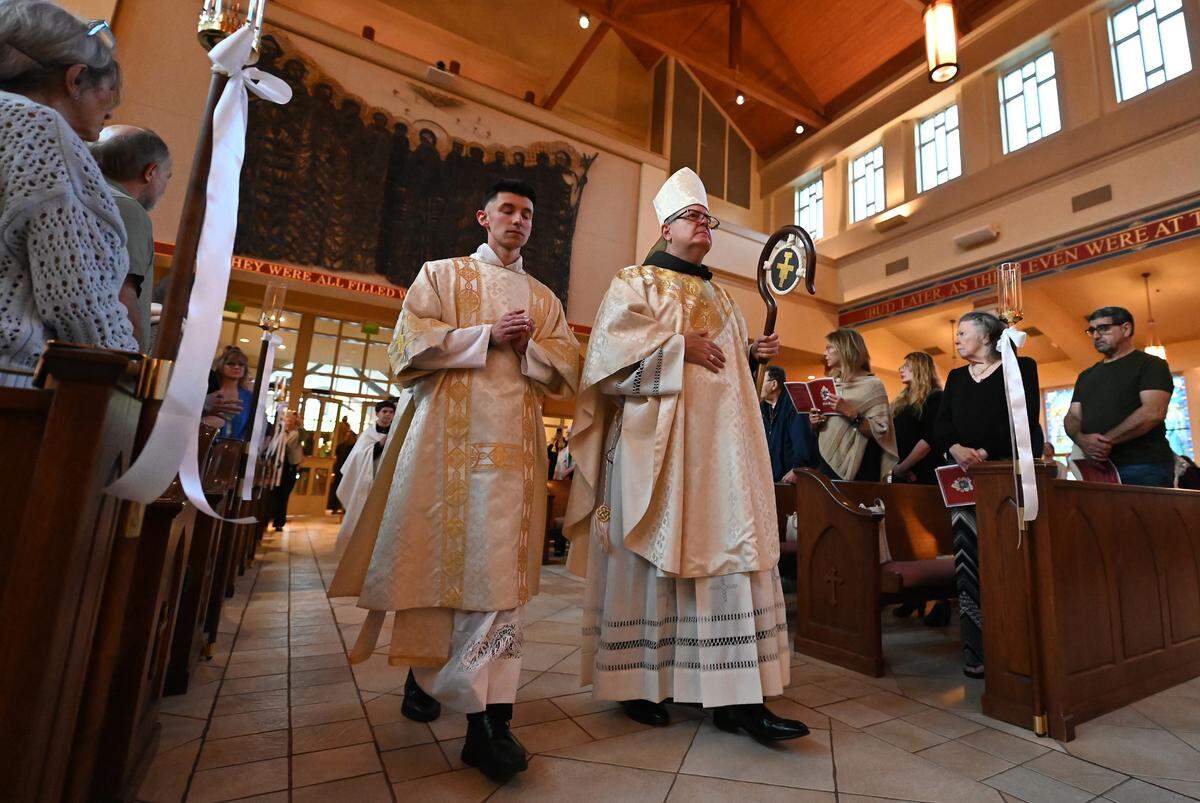 Fifth Bishop of Charlotte Michael T. Martin, right, enters a Mass for Deceased Pope Francis on Wednesday at Saint Mark Catholic Church in Huntersville. Bishop Martin gave the homily.
