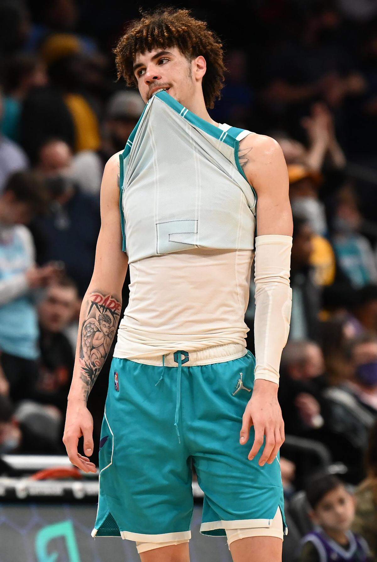 Charlotte Hornets guard LaMelo Ball bites down on his jersey after fouling out against Miami Thursday.