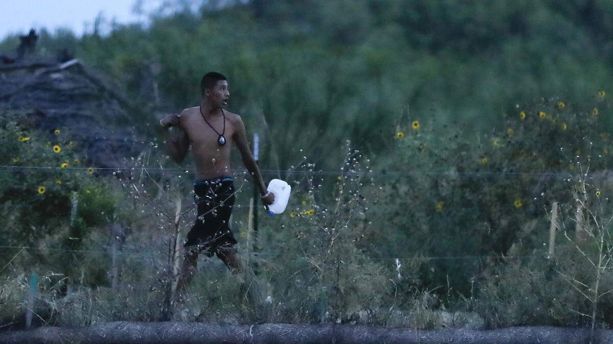 A “coyote” runs along the outskirts of Colonia Delacruz after escorting a group of immigrants across the Rio Grande last August.