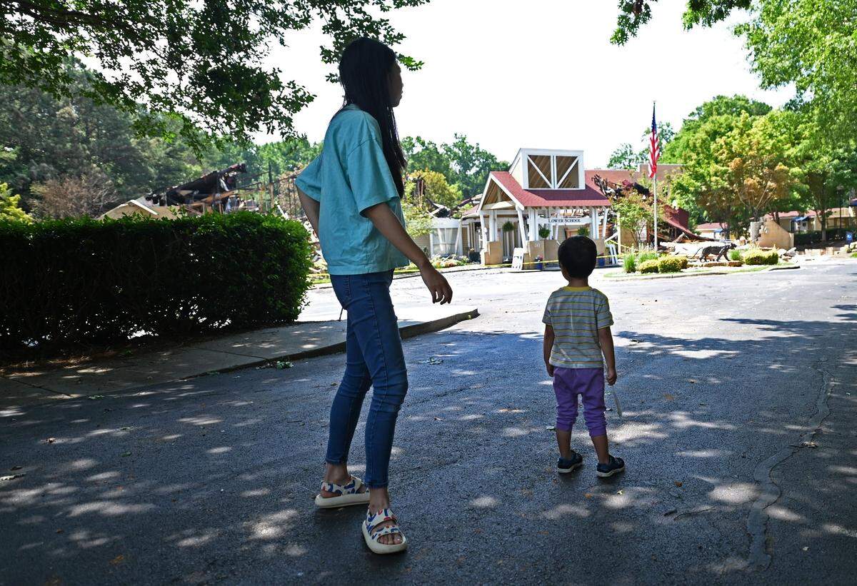 Donna Ren, left and her son, Darren Tang, right, look at the damage to The Lower School at the Charlotte Preparatory School on Tuesday, June 27, 2023. Darren Tang is in the school’s pre-primary school and summer camp program. The school sustained an estimated $2.5 million in damage following a three-alarm fire that erupted on Monday, June 26, 2023. More than 60 Charlotte firefighters responded to the call. The cause of the fire remains under investigation. The school posted online that no injuries were reported. All of the camps and activities at the school have been canceled for the remainder of the week.