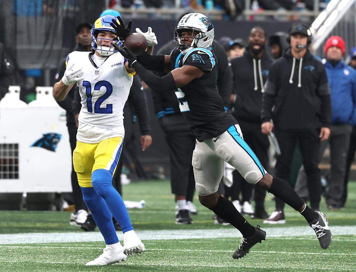 Carolina Panthers cornerback Mike Jackson, right, intercepts a pass meant for Los Angeles Rams wide receiver Puka Nacua, left, on Nov. 30. 