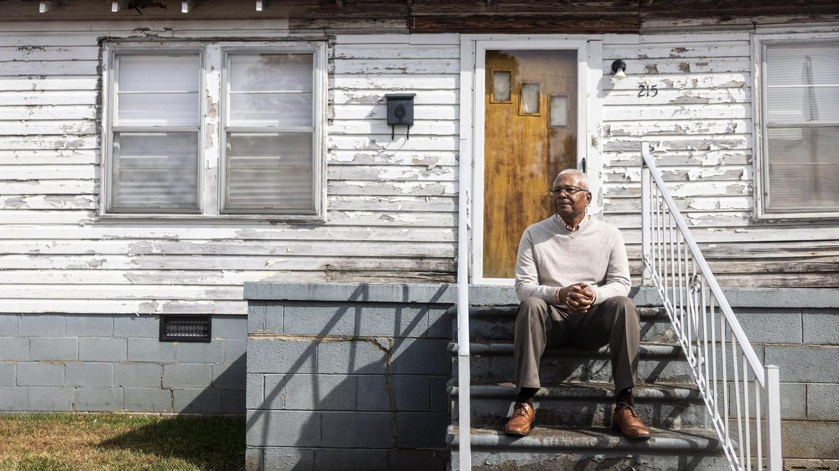 A.J. Clark poses for a portrait on the steps of what used to be his mother’s house in Concord, N.C., on Friday, October 28, 2022.