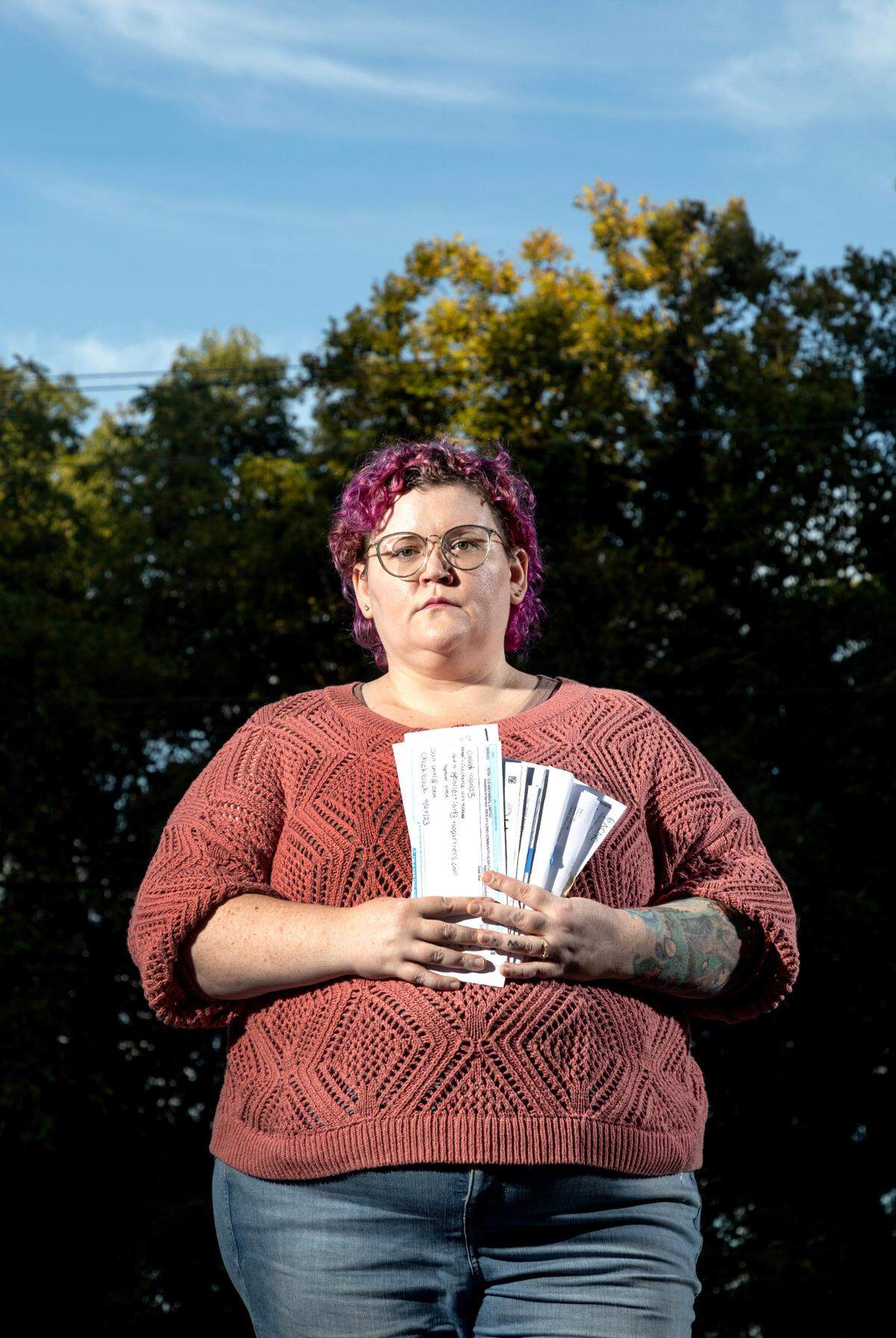 Jordan Montanez, outside her home in Greensboro, holds some of her many medical bills. She said she had to work for a full year to get hospitals to cover her bills - even though she had less than $10,000 in annual income.