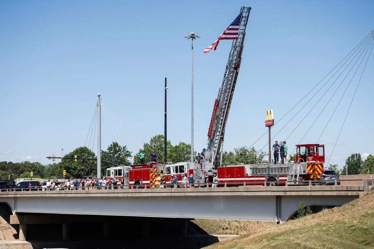Spectators join the Cornelius Fire Department on the bridge at exit 28 for the Deputy U.S. Marshal Thomas “Tommy” Weeks Jr. on Tuesday, May 1, 2024. Weeks, a 48-year Mooresville father of four, died in Monday’s Charlotte shooting where four law enforcement officers died and four more wounded.